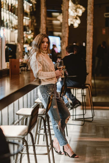 Elegante donna che beve vino al bancone nel bar — Foto stock