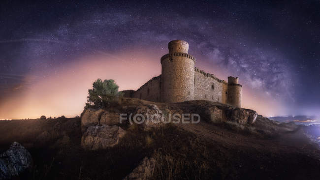 Misteriosa fortaleza antigua arruinada en la noche cielo estrellado fondo - foto de stock