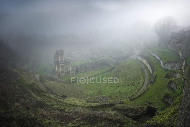 Dall'alto veduta delle rovine verdi muschiate nella nebbia pesante, Italia — Foto stock