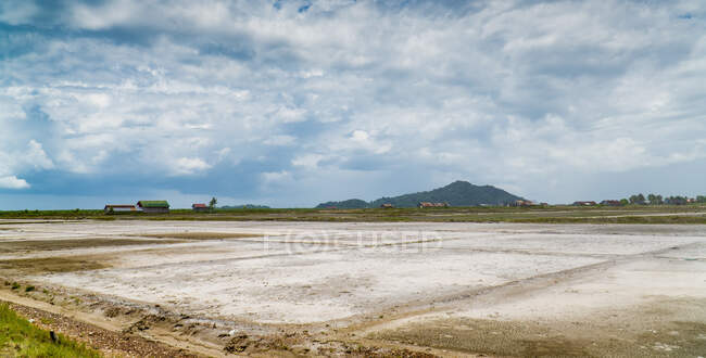 Vista del amplio terreno con campos en el campo tropical bajo el cielo nublado, Camboya - foto de stock