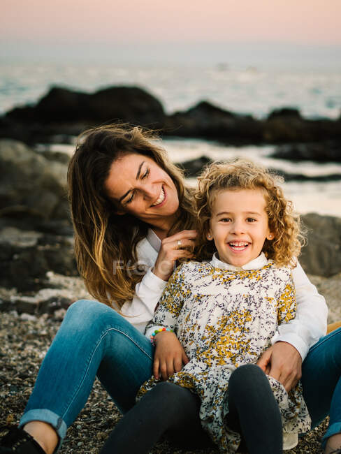 Middle aged woman with her daughter at sea shore smiling and hugging each other — Stock Photo