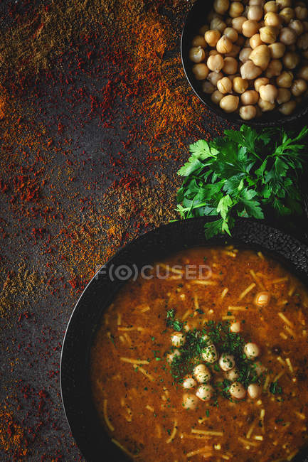 Zuppa tradizionale Harira per Ramadan in ciotola nera su sfondo scuro con ingredienti — Foto stock