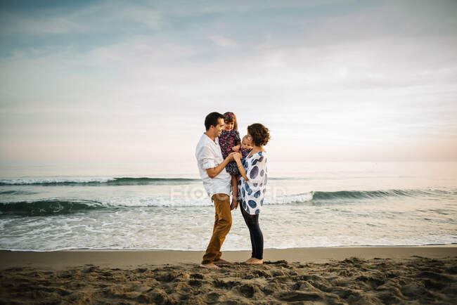 Family standing on beach — Stock Photo