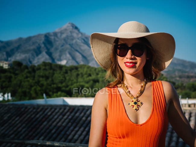 Junge elegante Chinesin mit Panamahut und Sonnenbrille genießt einen strahlenden Sommertag — Stockfoto