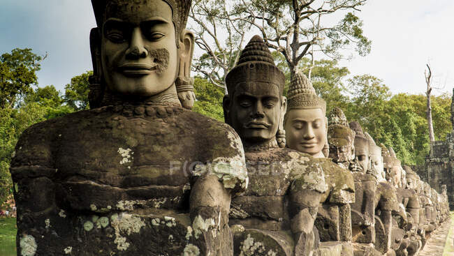 Estátuas de pedra antigas de Buda colocadas em linha no terraço do templo, Camboja — Fotografia de Stock