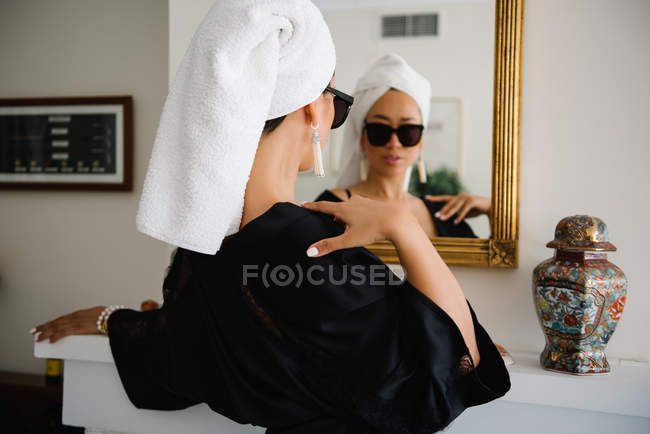 Elegant chinese wealthy woman getting ready in front of a mirror — Stock Photo