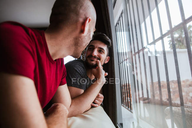 Романтична гей пара стоїть біля вікна разом — стокове фото