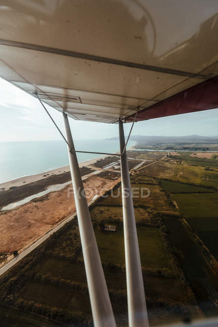 Vista del ala del avión en vuelo sobre la costa mediterránea - foto de stock