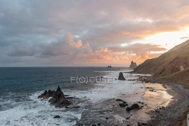Picturesque view of rocky cliffs in amazing sea on dramatic cloudy day in Playa Benijo Tenerife Spain — Stock Photo