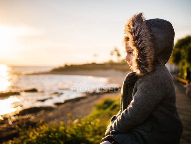 Vista lateral de uma menina pensativa na praia no inverno — Fotografia de Stock