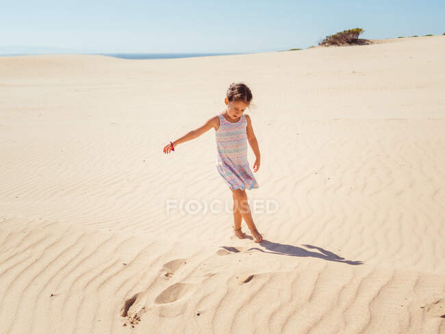 Симпатична маленька дівчинка грає з піском на пляжі — стокове фото