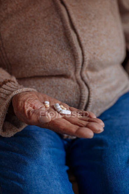 Dettaglio di pillole sulla mano di un vecchio — Foto stock