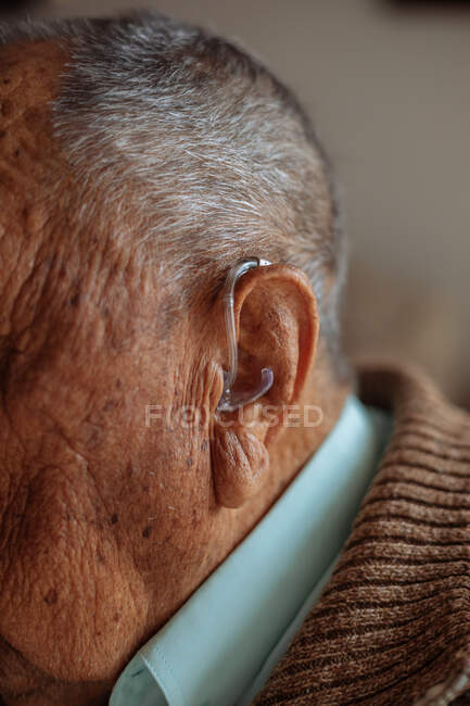 Detalle de un audífono en un anciano - foto de stock