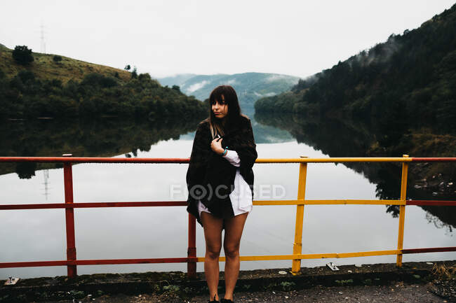Donna in piedi cercando incredibile lago vicino alle montagne — Foto stock