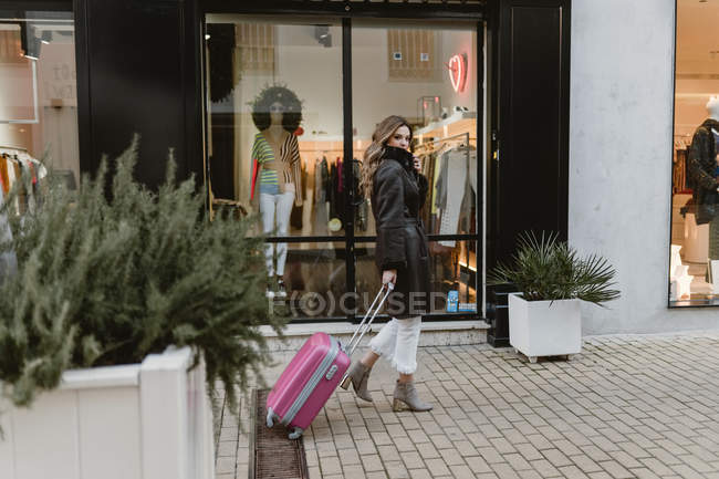 Mulher elegante com mala andando na rua — Fotografia de Stock