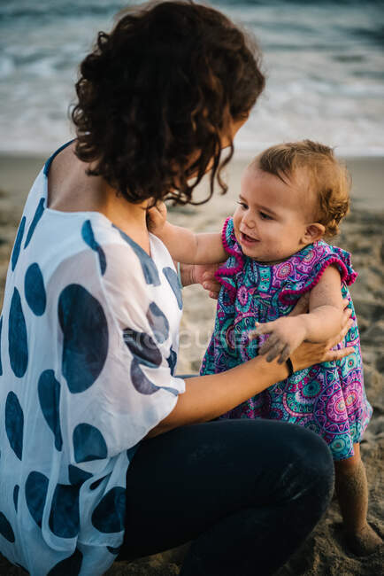 Mère jouant avec l'enfant sur la plage — Photo de stock