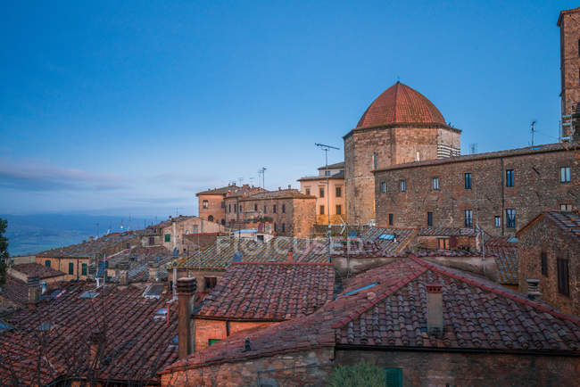 Exterior of old red brick buildings of Volterra town against blue sky, Italy — Stock Photo