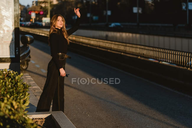 Стильна молода жінка вимотує таксі на міській вулиці — стокове фото