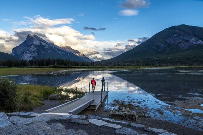 Personnes debout sur une jetée près d'un lac étonnant — Photo de stock