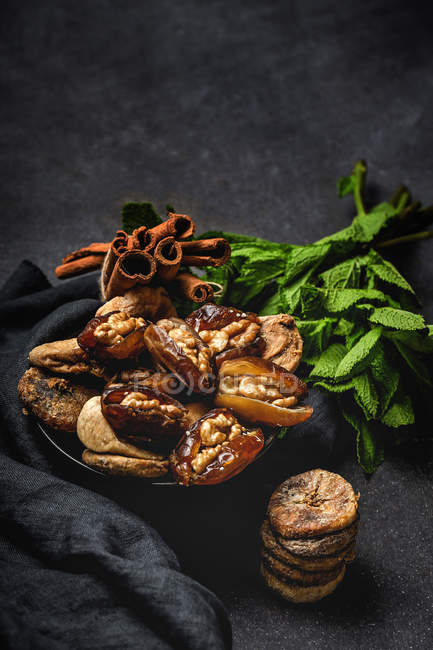 Dried dates, figs, fresh mint and cinnamon for halal snack for Ramadan — Stock Photo