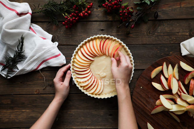 Unerkennbare Frau backt Apfelkuchen auf Holztisch — Stockfoto