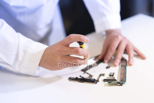 Молодой человек ремонтирует современное устройство — стоковое фото