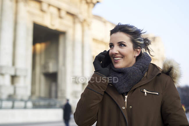 Mujer joven en ropa de invierno hablando por teléfono al aire libre en Milán Italia - foto de stock
