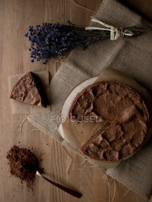 Вид сверху бесплатного шоколадного торта в деревянной столешнице и букета лаванды на кухне
. — стоковое фото