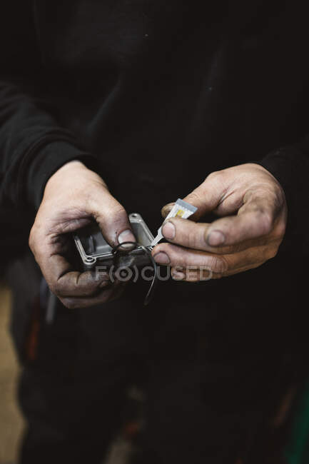 Невпізнаваний ремонтник з брудними руками приклеює зламану частину в майстерні — стокове фото
