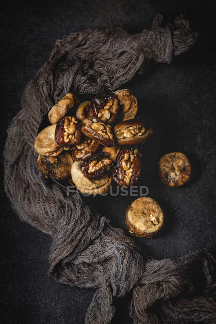Halal snack for Ramadan with dried figs, dates and walnuts on black background — Stock Photo