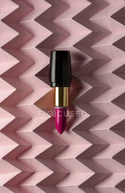 Lipstick on raised pink chevron. Product and make up concept — Stock Photo