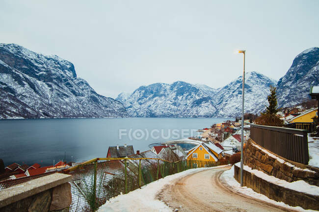 Pequeña ciudad cerca del mar y las montañas nevadas - foto de stock