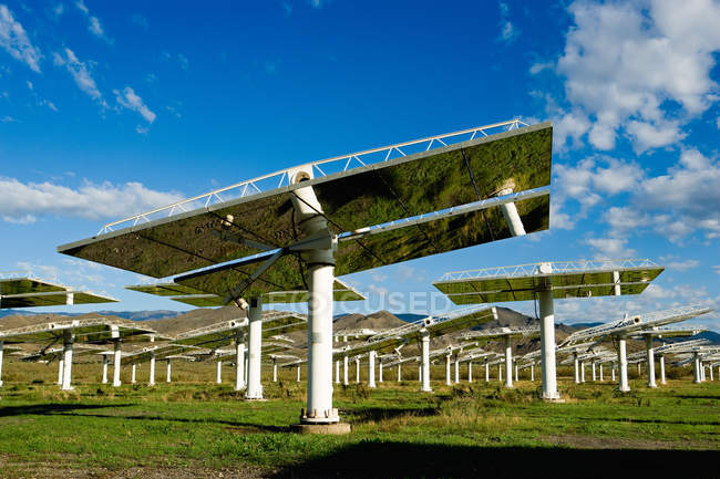 Painéis solares na estação de energia sob o céu azul com nuvens — Fotografia de Stock