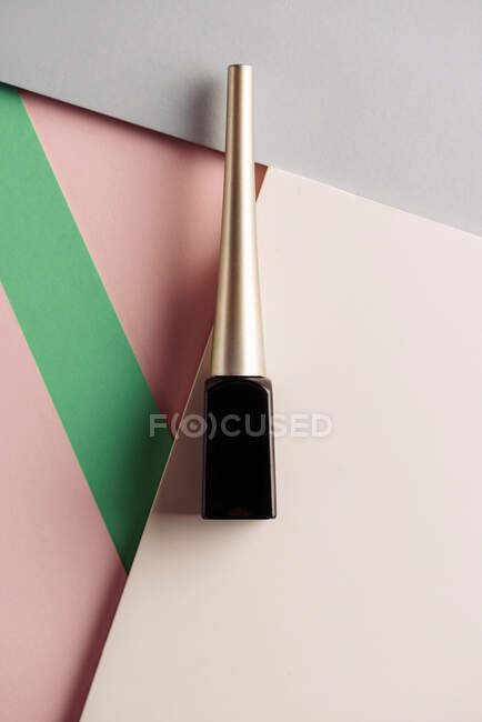 Flüssiger Eyeliner-Pinsel, auf attraktivem Hintergrund, in pastellrosa und grünen Farben. Produkt- und Make-up-Konzept. Von oben — Stockfoto