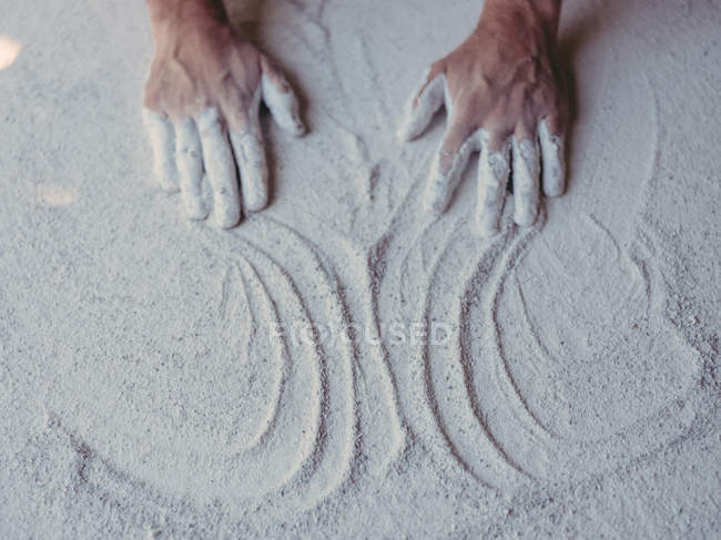Mani di anonimo artista maschio diffusione grezzo intonaco bianco su superficie piana in officina — Foto stock