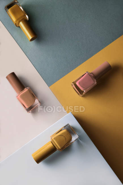Smalti per unghie multicolori su sfondo modello geometrico colori — Foto stock