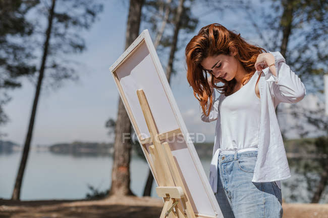 Young woman putting on her shirt in countryside — Stock Photo