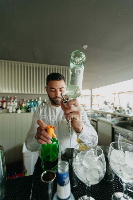 Bartender pouring alcoholic drink to shaker in bar — Stock Photo