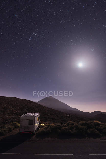 Мандрівний караван в пустелі з яскравим місяцем і зоряним небом — стокове фото