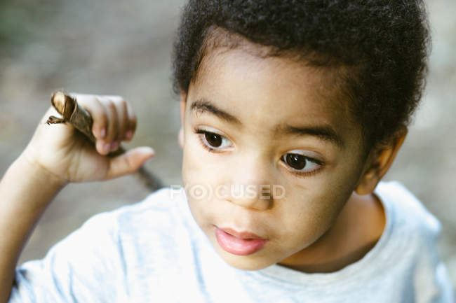 Funny African American child with stick playing outdoors — Stock Photo