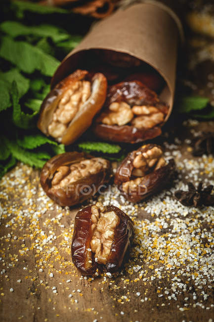 Dried dates, figs, fresh mint and cinnamon for halal snack for Ramadan wrapped in parchment — Stock Photo
