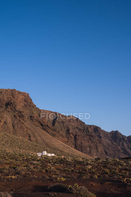 Barren landscape of rocky mountain on background of blue sky — Stock Photo