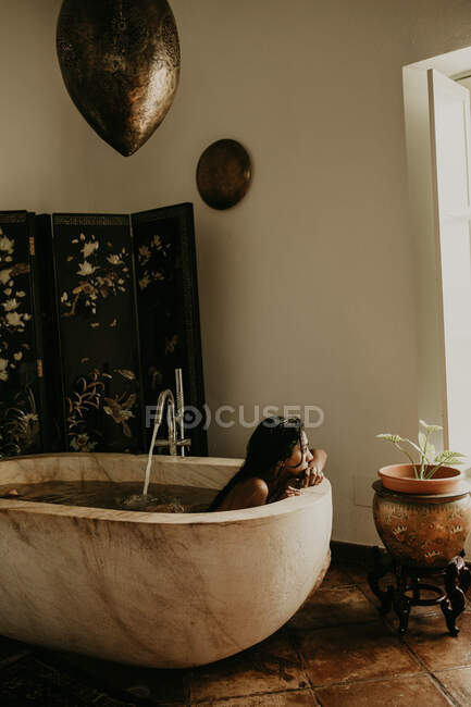 Вид сбоку на красивую женщину, принимающую ванну в деревенском доме — стоковое фото