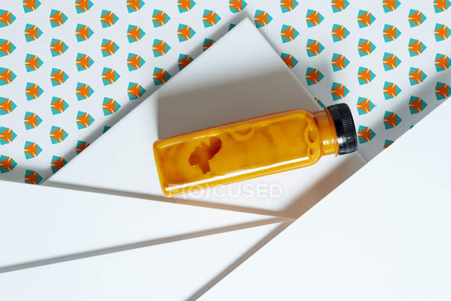 Frasco de smoothie de manga e abóbora sobre textura geométrica de estilo retro — Fotografia de Stock