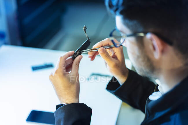Young man repairing modern device — Stock Photo