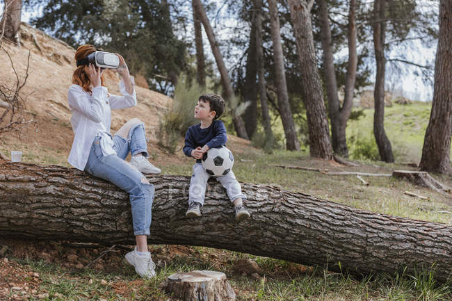 Niño mirando a la madre en los auriculares VR - foto de stock