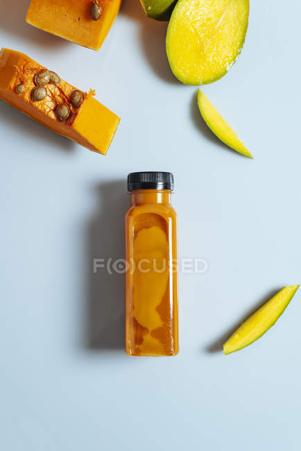 Манго і гарбуз вегетаріанець коктейль в пляшці на білому фоні інгредієнти — стокове фото