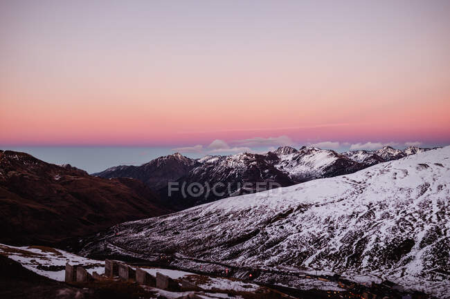Céu de pôr-do-sol claro sobre a maravilhosa gama de montanhas coberta com neve branca — Fotografia de Stock