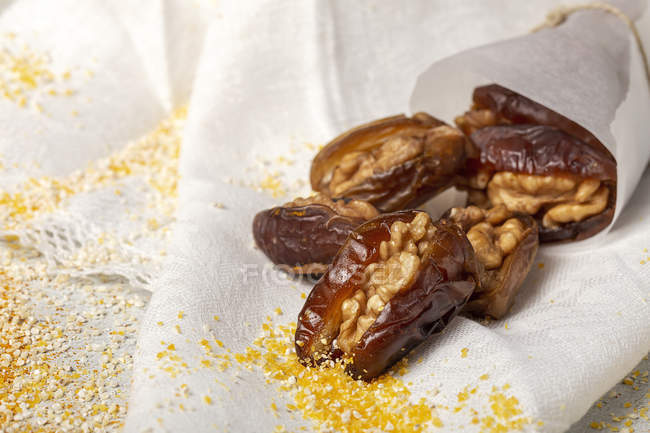 Snack halal para Ramadán con dátiles secos y nueces sobre tela blanca - foto de stock