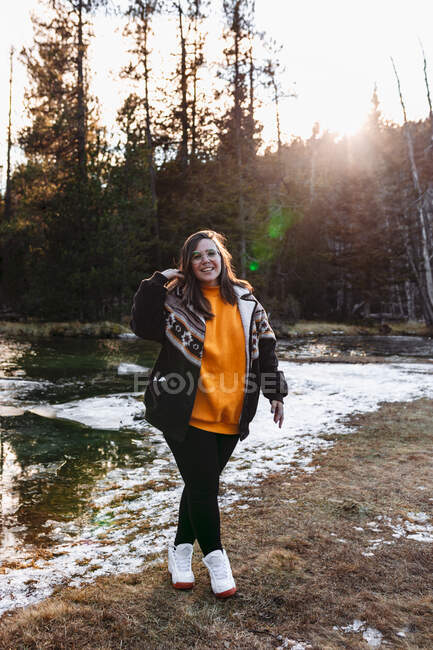 Fröhliche junge Frau auf Teich im Wald — Stockfoto